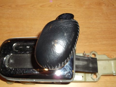 1999 Mercury Grand Marquis - A close-up view of a black leather automatic gear shifter knob and part of the shifter assembly, likely from a 1999 Mercury Grand Marquis,…