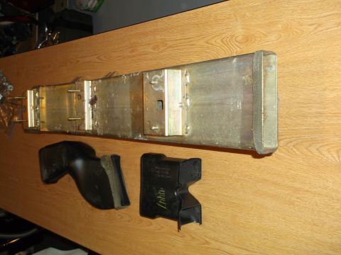1999 Mercury Grand Marquis - A metal air intake duct with two black rubber or plastic connectors sits on a wooden surface. The metal duct appears to be part of a vehicl…