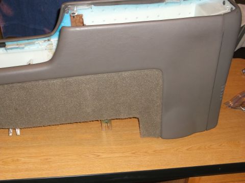 1999 Mercury Grand Marquis - A close-up view shows the interior trim of a vehicle's center console, featuring grey plastic and carpeted sections. The console is placed…