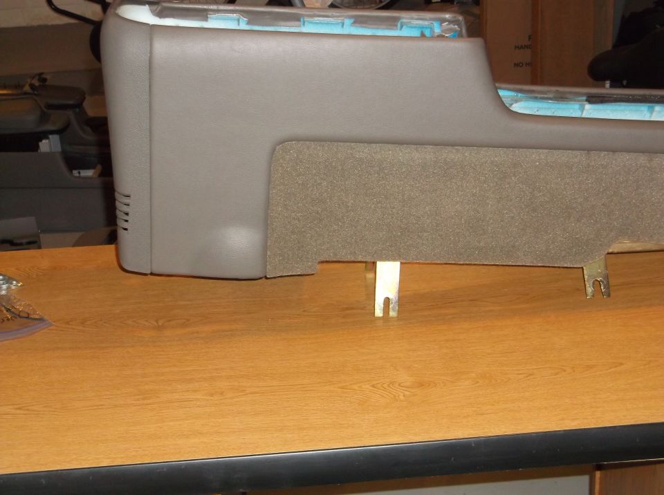 Gray center console part with textured insert and metal brackets