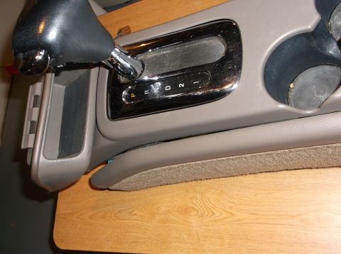 1999 Mercury Grand Marquis - Close-up of a car's automatic transmission shifter and gear selector with P, R, N, D, 2, 1 indicators. A storage compartment and cup holder…