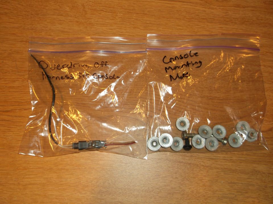 Two plastic bags with labels and contents on a wooden surface.