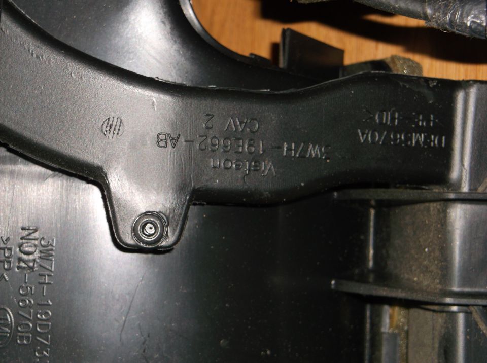 Black plastic automotive part with embossed text: Visteon 3W7H-19E662-AB CAV 2, DEM5670A, 3W7H-19D733 NO7-5670B