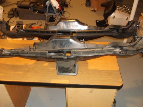 1999 Mercury Grand Marquis - Two black plastic automotive air intake manifolds are displayed on a wooden table. The manifolds appear to be from the same model vehicle,…