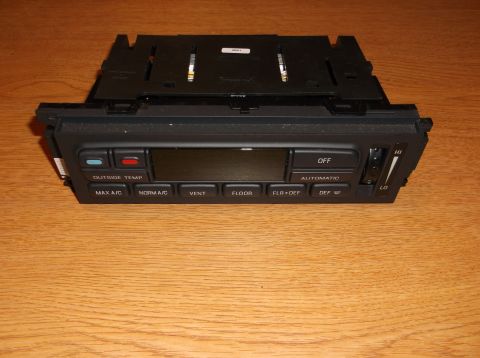 1999 Mercury Grand Marquis - A front view of a black climate control unit from a 1999 Mercury Grand Marquis. The unit features several buttons, a digital display, and a…