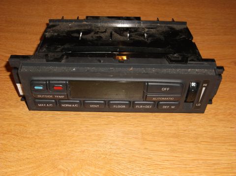1999 Mercury Grand Marquis - A close-up, front-facing view of a car's climate control unit with buttons and a digital display. The unit is black and mounted on a wooden…