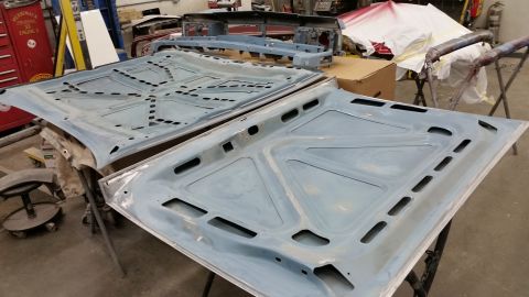 2001 Ford Crown Victoria - Photograph of primered automotive floor pan panels on stands, not a technical document.