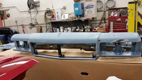 2001 Ford Crown Victoria - Photograph of primered automotive parts on a bench in a body shop, not a technical document.