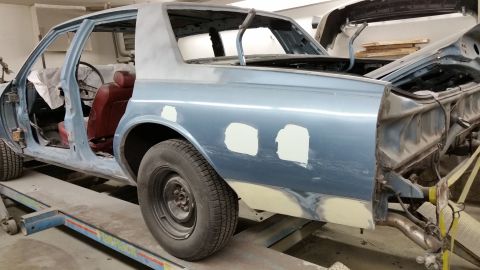 2001 Ford Crown Victoria - Photograph of a sedan body shell on a frame rack during bodywork, not a technical document.