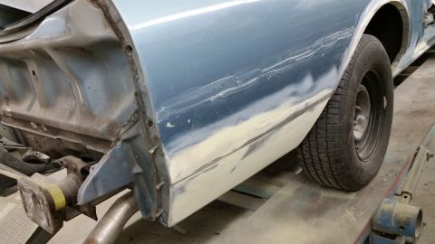 2001 Ford Crown Victoria - Photograph of a car quarter panel and wheel during restoration, not a technical document.