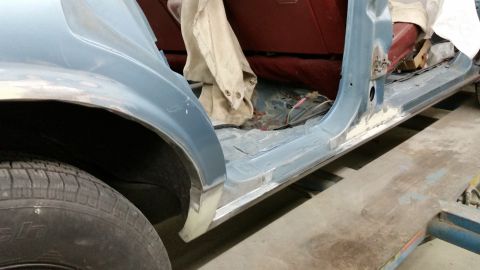 2001 Ford Crown Victoria - Photograph of a car rocker panel and wheel arch during bodywork, not a technical document.