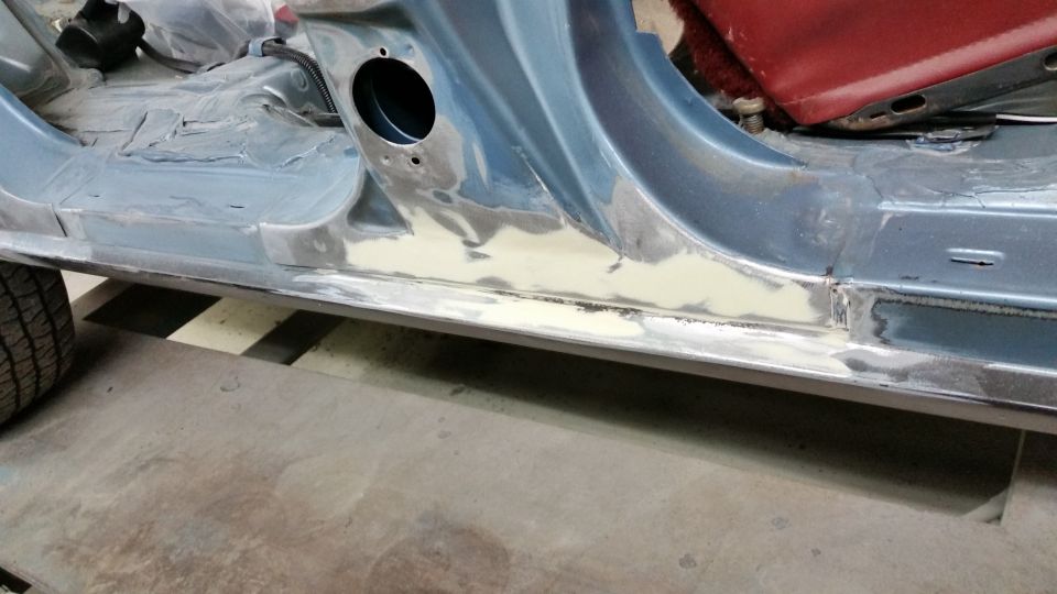 Photo of a bare-metal repaired rocker panel on a car body