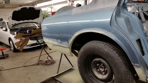 2001 Ford Crown Victoria - Photograph of a car body and wheel in a shop, not a technical document.