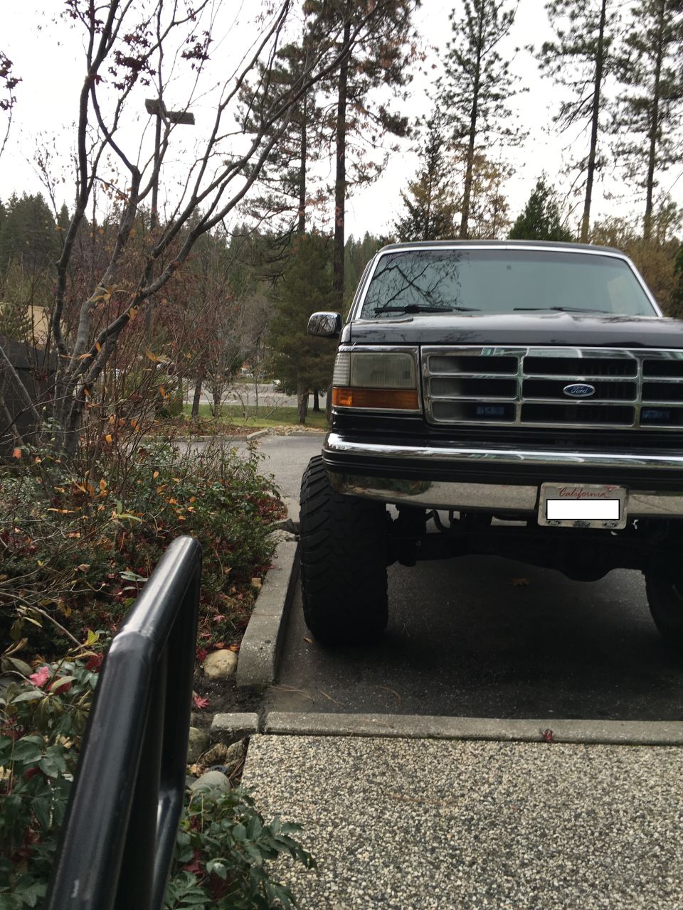 Front view of a black Ford Bronco with large tires parked outdoors.