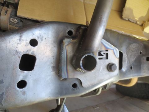 1996 Ford Bronco - A close-up view of a modified vehicle frame with a welded support bracket and a large bolt. The frame appears to be made of steel and shows…
