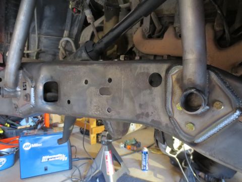 1996 Ford Bronco - Close-up view of the heavily modified frame of a 1996 Ford Bronco, showing custom welds and fabricated brackets. A blue Miller welding mach…