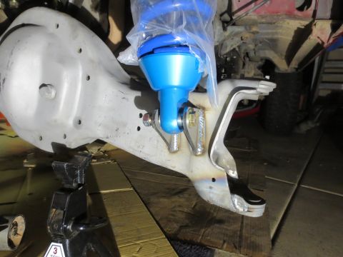 1996 Ford Bronco - A close-up view of the suspension components of a 1996 Ford Bronco, showing a blue shock absorber assembly attached to a silver differentia…