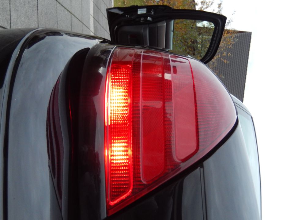 Illuminated red taillight of a dark Mercury Marauder with the rear hatch open.