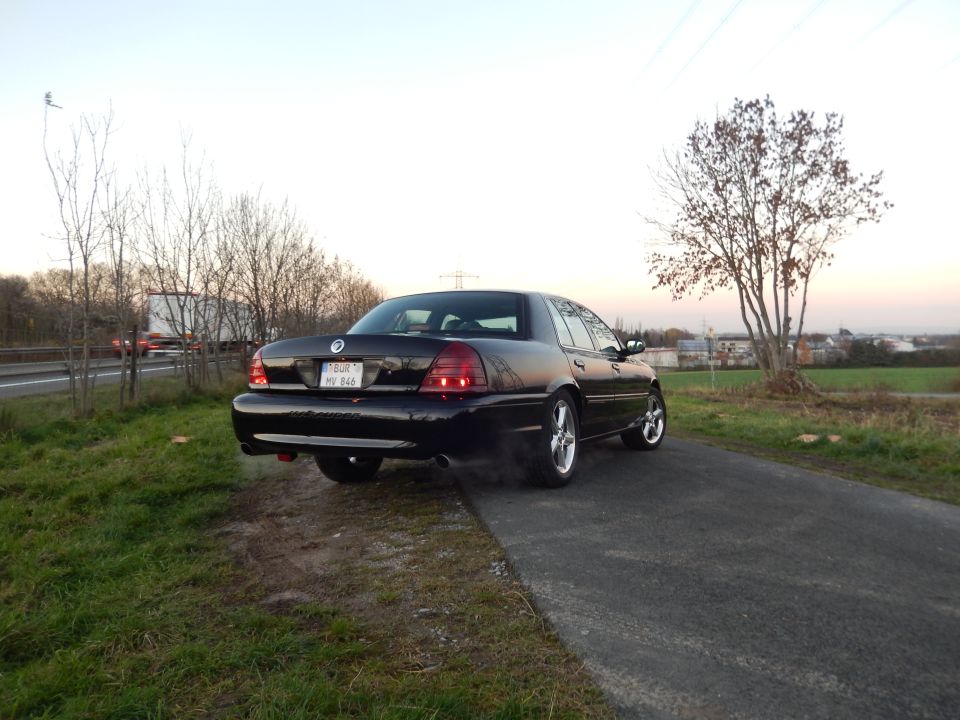 Black 2003 Mercury Marauder parked on the side of the road, rear view.