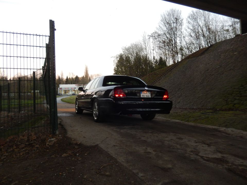 Black 2003 Mercury Marauder rear driver's side view parked on dirt road.