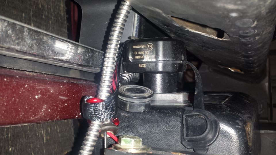 Close-up of a black vehicle electronic component with text and wiring.