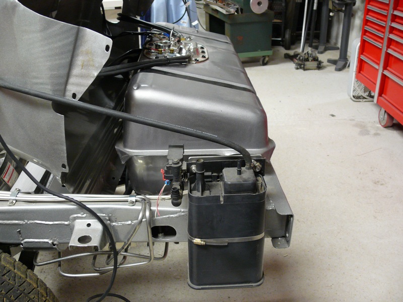 Custom fuel tank and charcoal canister assembly mounted on a vehicle frame.