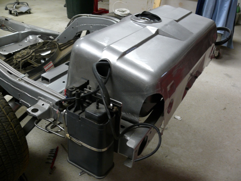 Silver fuel tank assembly mounted on vehicle chassis.