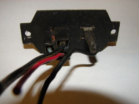 1973 Ford Ranchero - This is a close-up view of the back of a black electrical component with several wires attached. The component has two mounting holes and a…