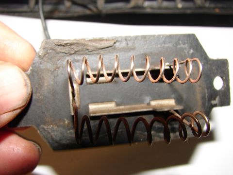 1973 Ford Ranchero - A close-up view of a blower motor resistor with two copper coils attached to a metal bracket. The bracket appears aged and somewhat corrode…