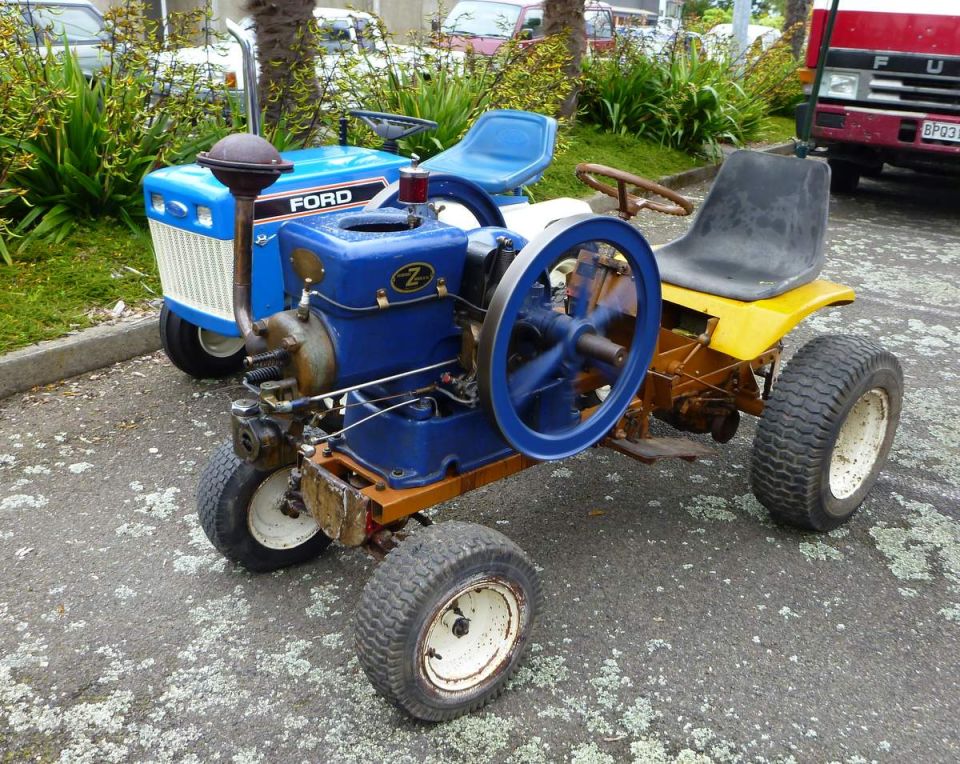 Custom blue and yellow tractor with a visible engine and flywheel.