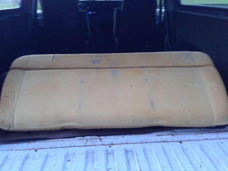 Tan foam seat cushion in the bed of a white pickup truck