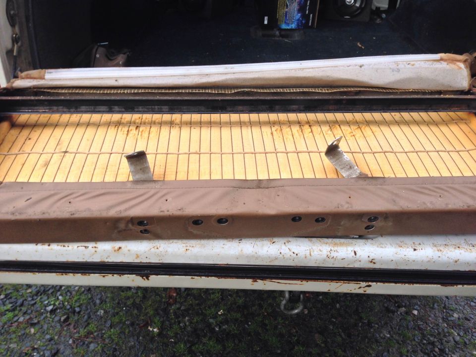 Disassembled vehicle seat cushion with yellow foam and metal springs.