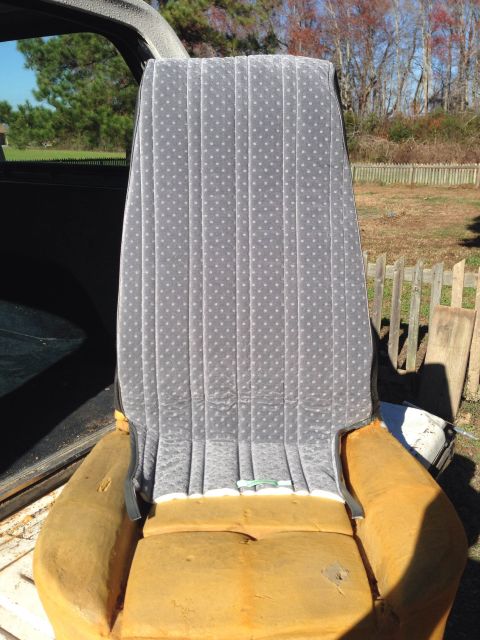 1979 Ford Bronco - A gray velour car seat with white polka dots and exposed yellow foam is shown from the front.