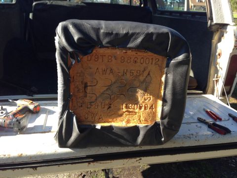 1979 Ford Bronco - A vehicle seat cushion is shown with part numbers stamped into the foam, resting on the tailgate of a vehicle.