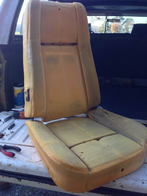 1979 Ford Bronco - The foam padding of a car seat is exposed, showing signs of wear and tear.