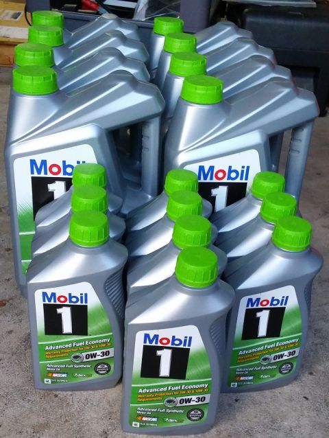 2000 Ford Crown Victoria - A collection of Mobil 1 0W-30 synthetic motor oil bottles with green caps are neatly arranged in rows.
