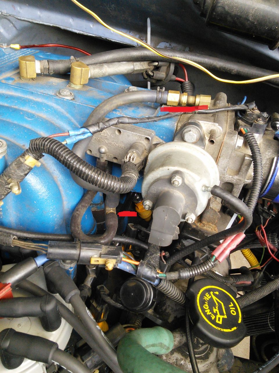 1996 Ford Bronco engine bay with fuel injectors, hoses, and wiring.