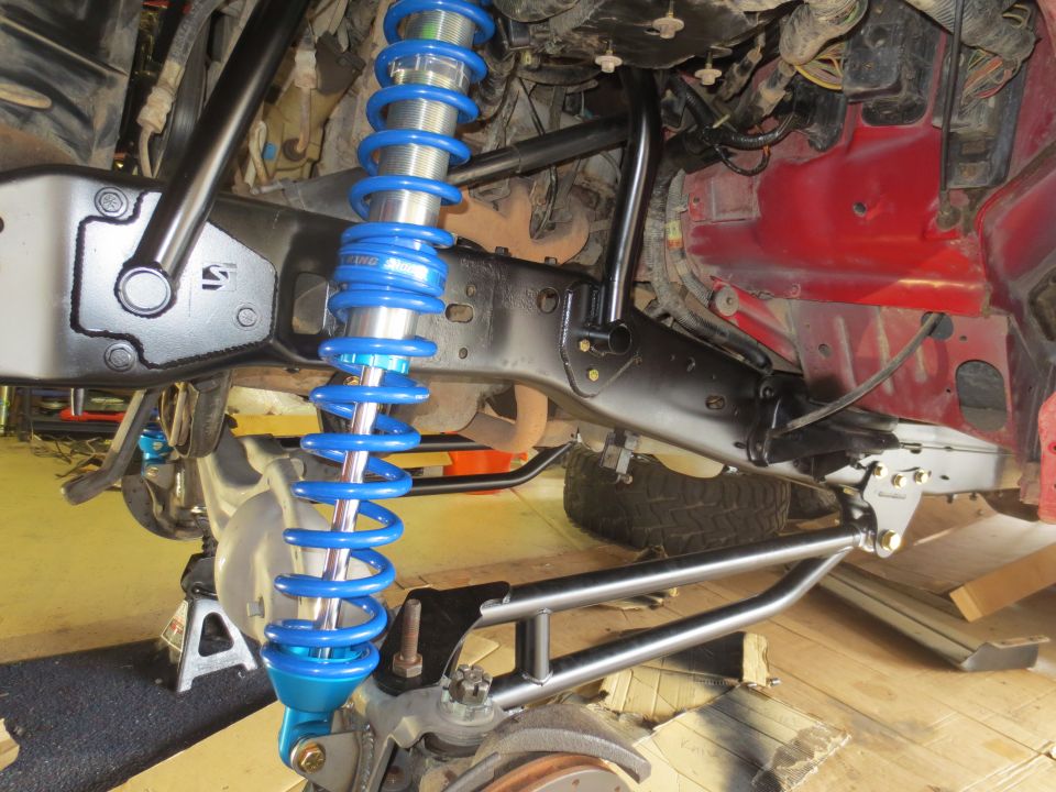 1996 Ford Bronco suspension with blue coilover shock and black components.