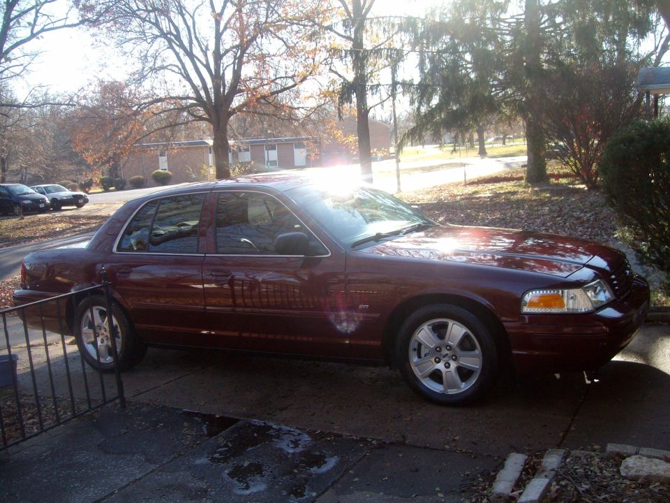 Maroon Ford Crown Victoria sedan parked on a driveway.