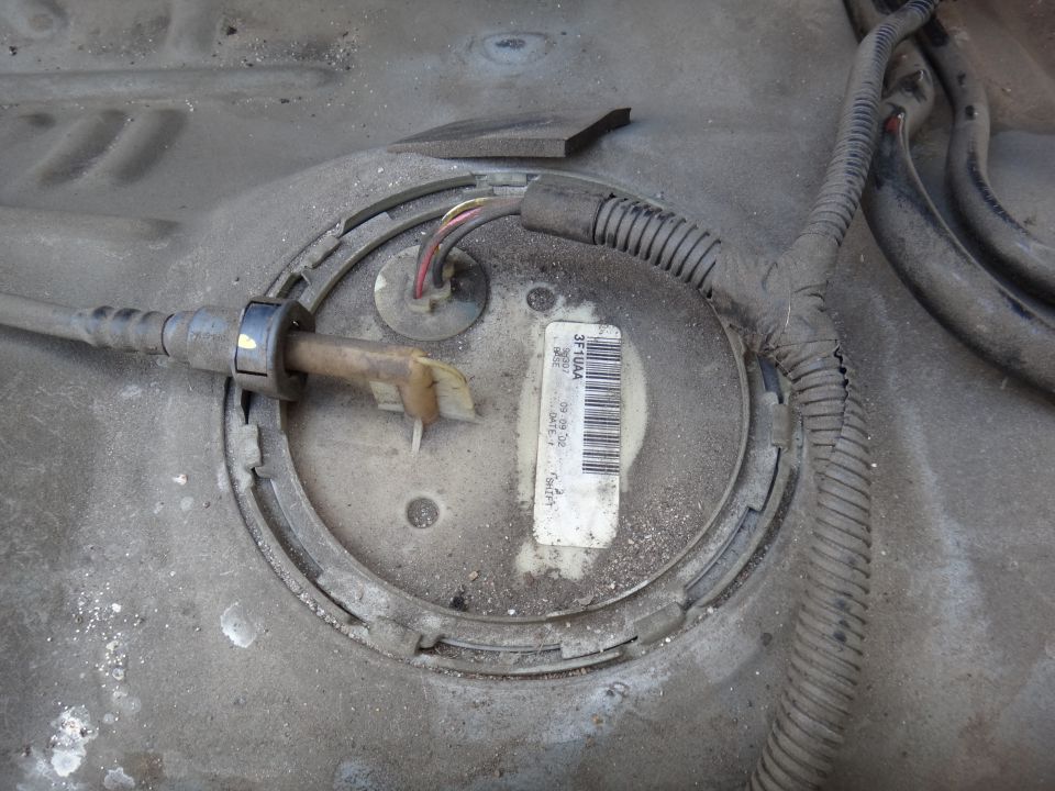 Fuel pump module assembly on vehicle fuel tank with barcode label and wiring.