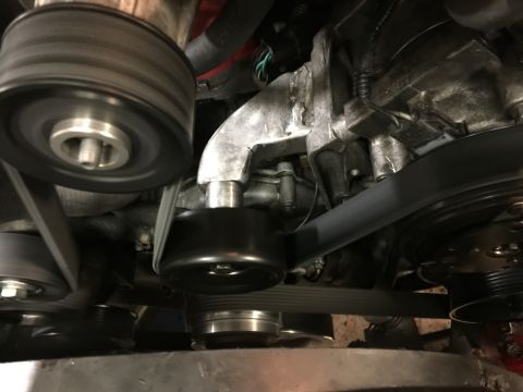 1996 Ford Bronco - A close-up view of the serpentine belt system on a Ford Bronco engine. Multiple pulleys and the ribbed belt are visible, along with parts o…
