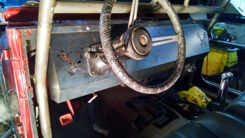 1985 Jeep CJ7 - The interior of a heavily modified vehicle features a roll cage and a custom dashboard with decorative cutouts.
