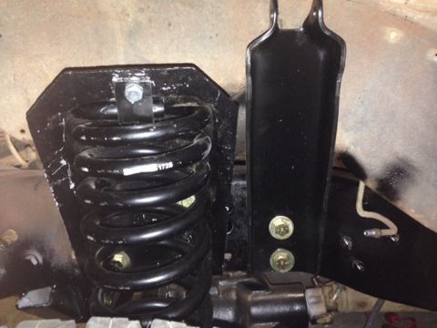 1981 Ford Bronco - Close-up view of a vehicle's suspension system, highlighting a coil spring and mounting hardware.