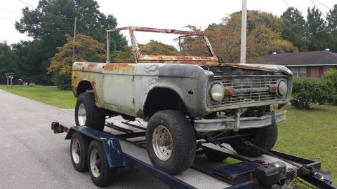 1972 Ford Bronco - This 1972 Ford Bronco is being transported on a trailer, showing significant rust and missing body panels.