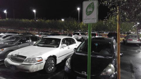 2004 Lincoln Town Car - A white 2004 Lincoln Town Car is parked in a lot at night next to a black car.