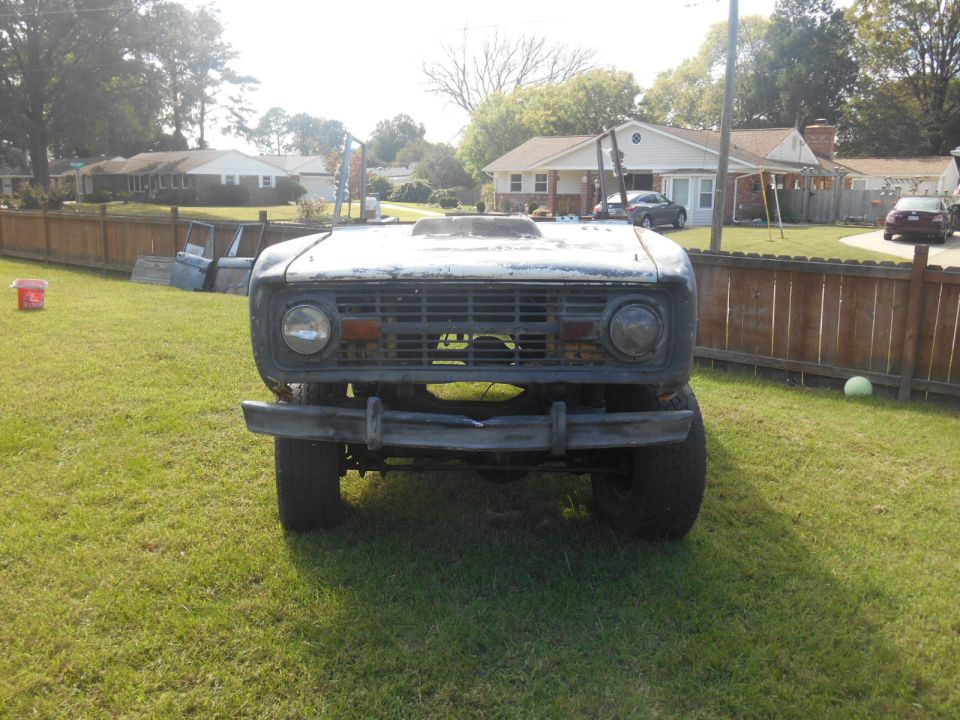 Front view of a 1972 Ford Bronco with a hood scoop and weathered grille