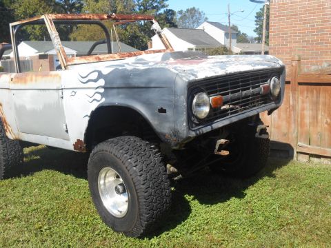 1972 Ford Bronco - This weathered Ford Bronco shows significant rust and custom flame graphics on its body panels.