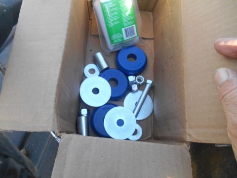 1972 Ford Bronco - A box contains various suspension bushings and hardware, including bolts and nuts.