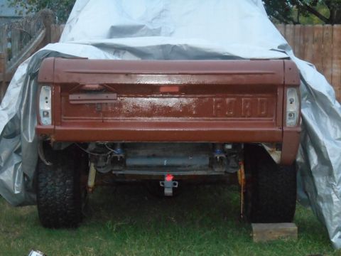 1972 Ford Bronco - Rear view of a 1972 Ford Bronco undergoing restoration, covered with a tarp.