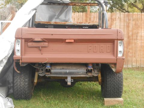 1972 Ford Bronco - Rear view of a brown Ford Bronco undergoing restoration, with visible suspension components and tailgate lettering.